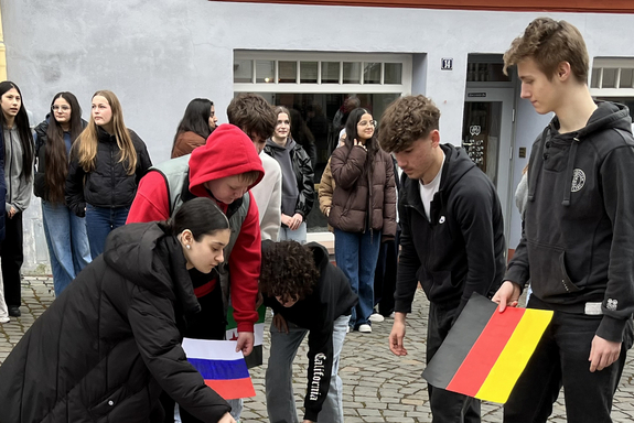 Schüler legen die Antionalflaggen zu einem großen Teppisch aneinander